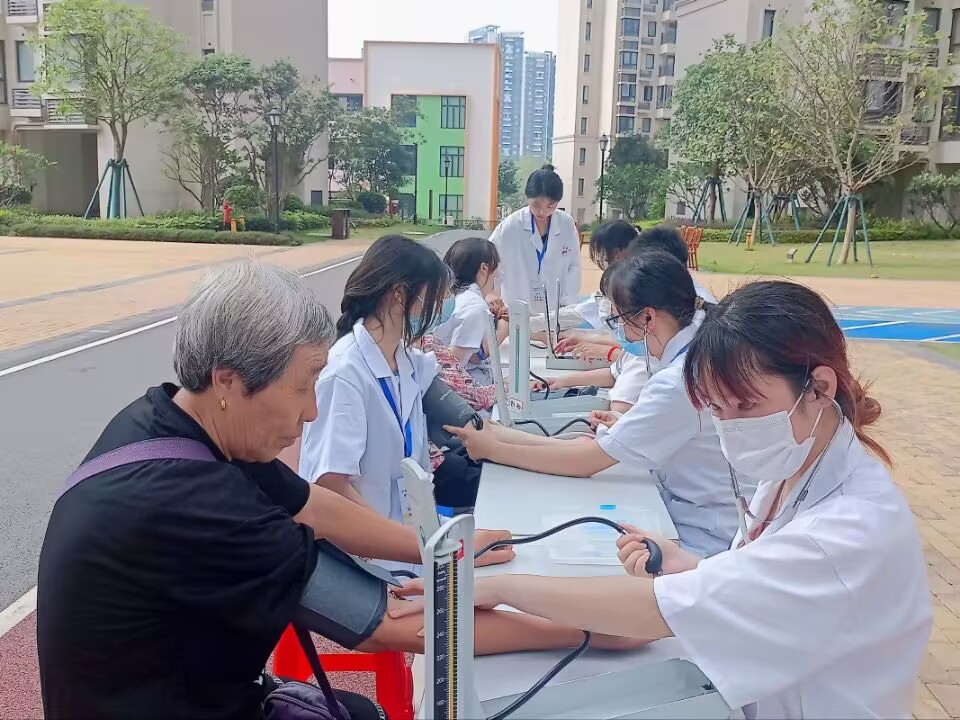 同学们在给社区居民们测量血压