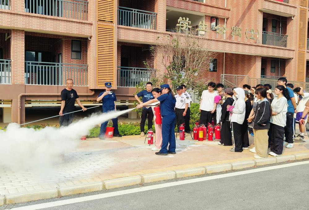 消防员指导学生进行灭火器操作