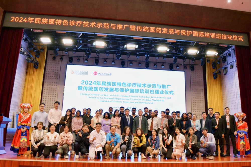 在国际培训班结业仪式上,广西国际壮医医院党委副书记、院长黄国东为学员们赠书 在国际培训班结业仪式上,广西国际壮医医院党委副书记、院长黄国东为学员们赠书